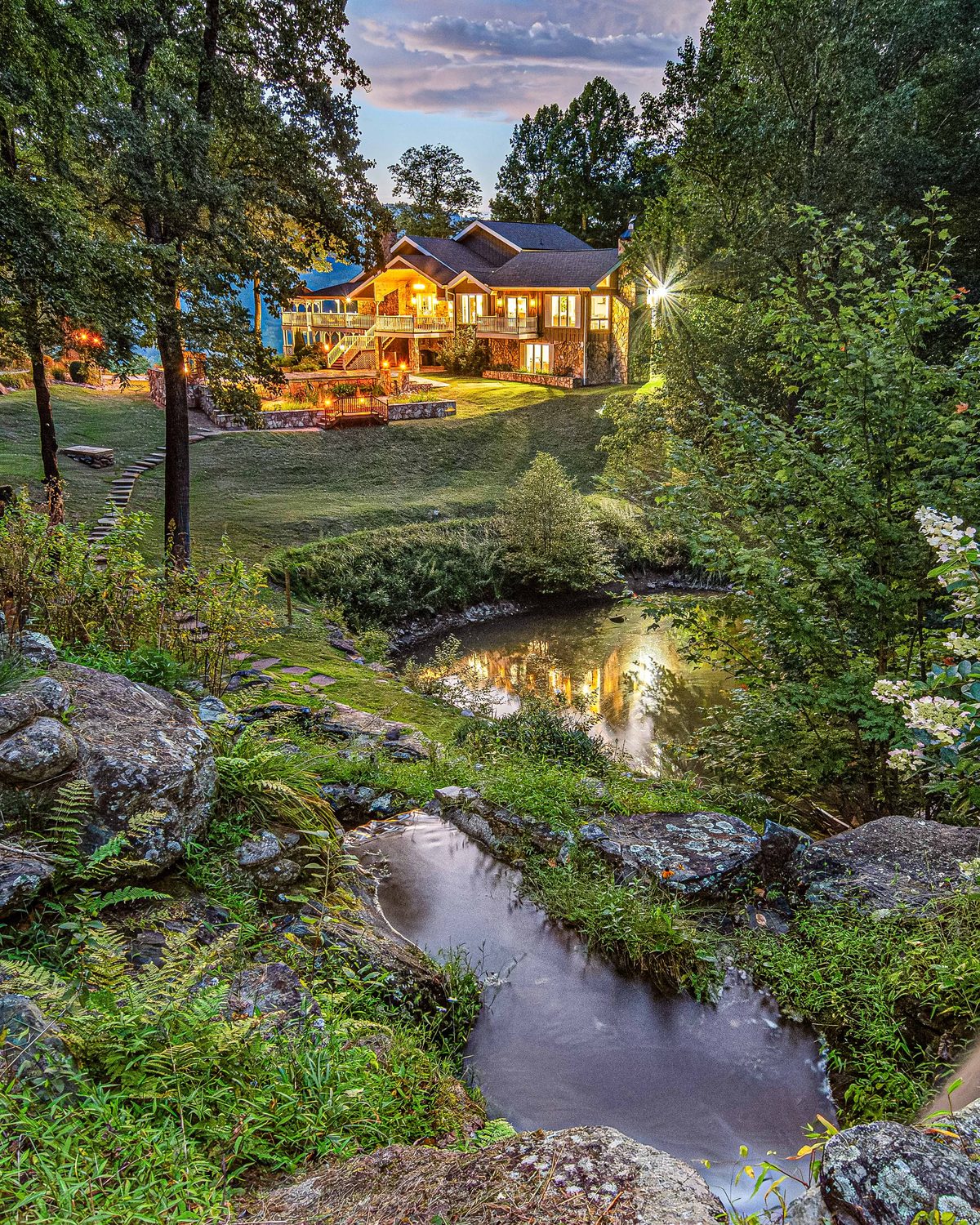 The residence at Hemingway Estates beside its private waterfall and koi pond in the forest